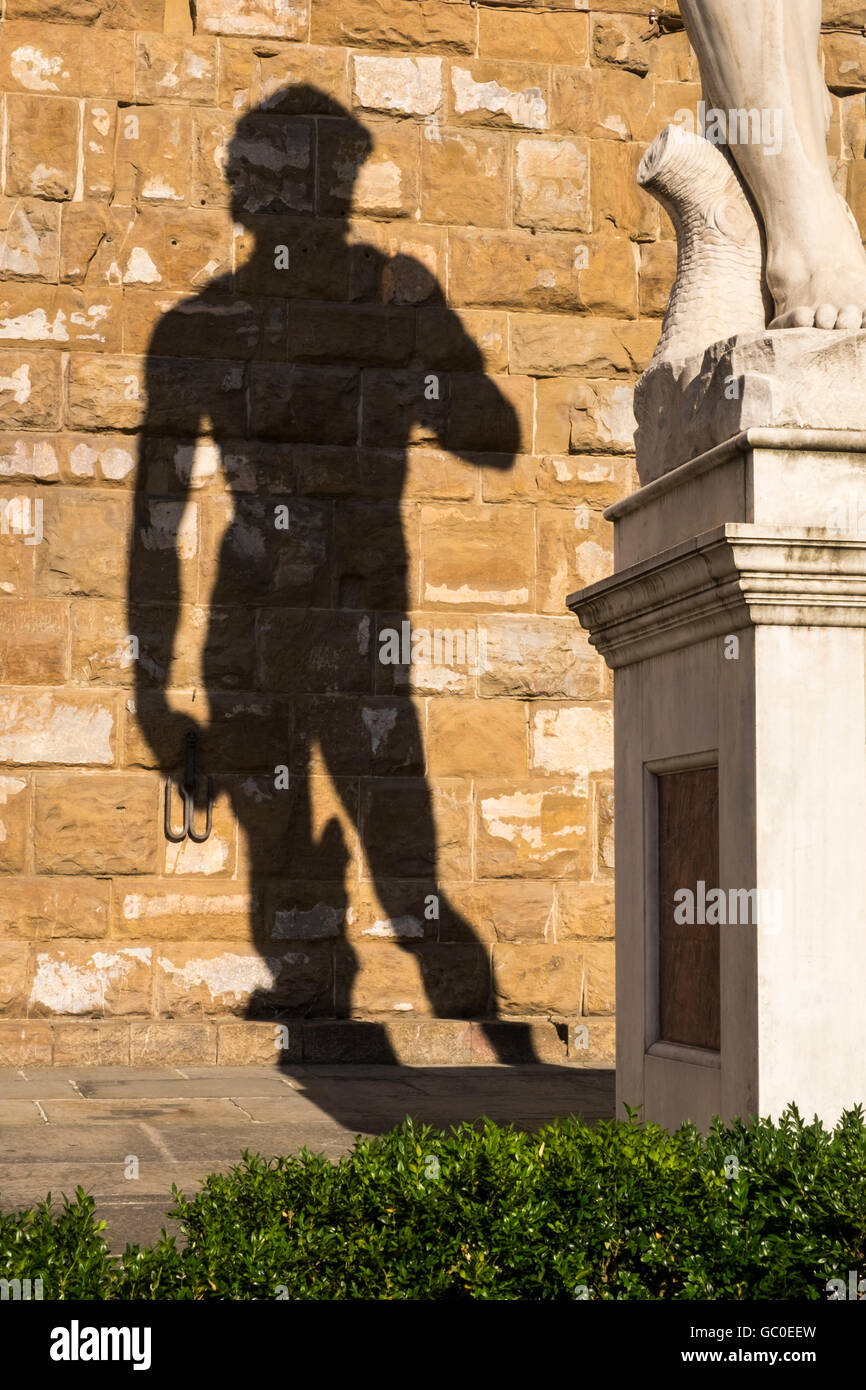 Ombra sul muro dietro la copia della statua di Davide di Michelangelo e nella Piazza della Signore, Firenze, Toscana, Ita Foto Stock