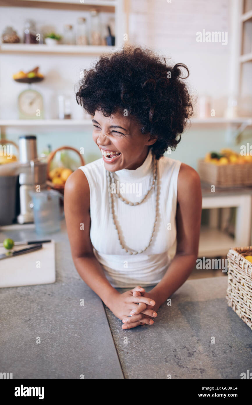 Ritratto di Allegro giovane donna in piedi dietro il contatore. Succo di successo proprietario del bar che guarda lontano e sorridente. Foto Stock
