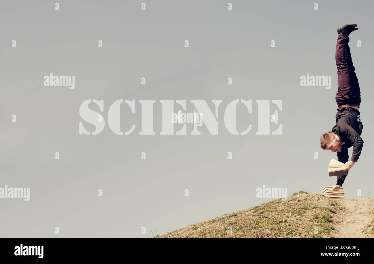 Parola di Scienza - Guy standing sulla sua testa e la lettura Foto Stock