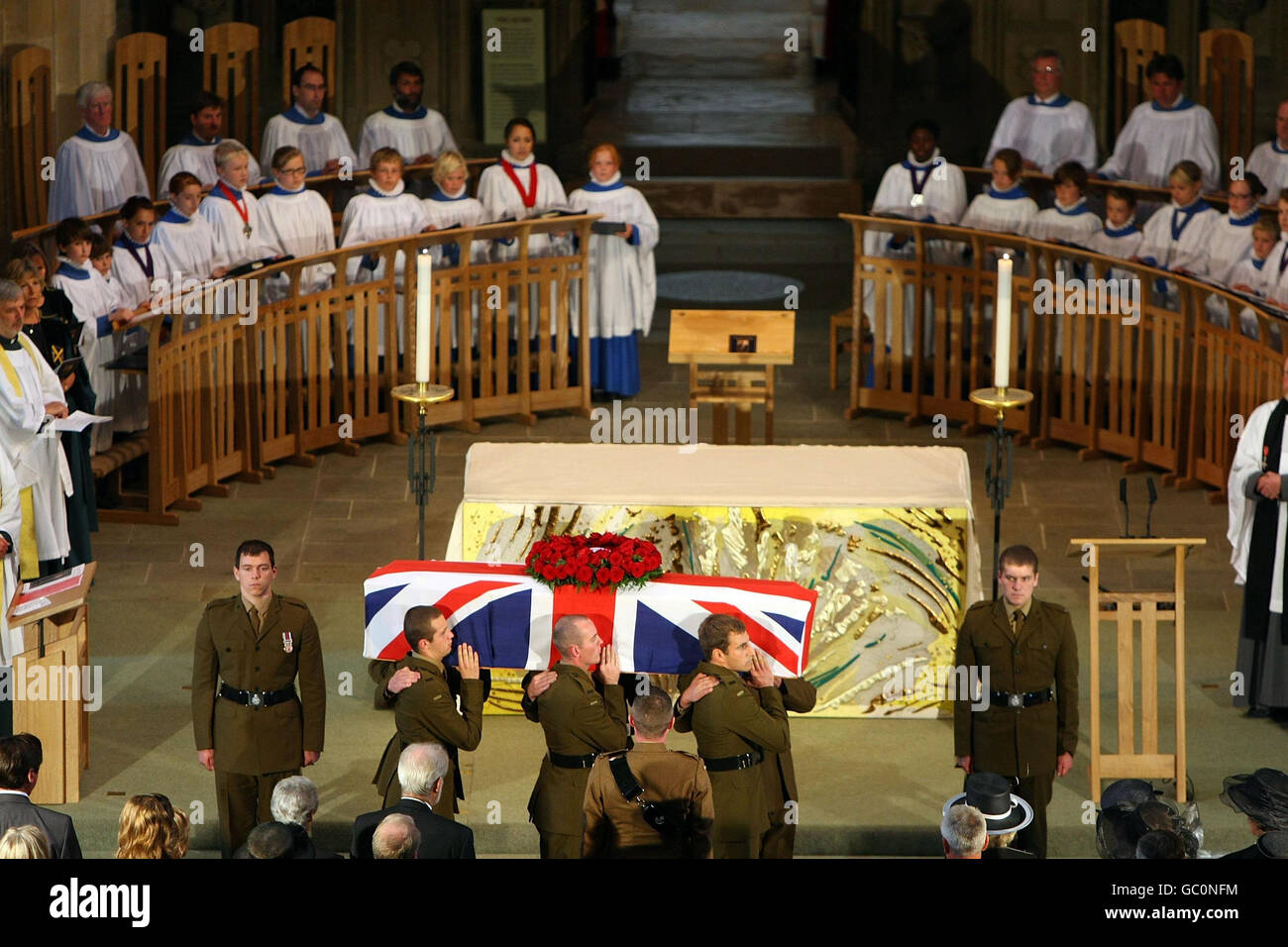 La bara drappeggiato bandiera del veterano della prima guerra mondiale Harry Patch viene effettuata dalla Cattedrale di Wells dai soldati dei fucili, dopo il servizio nel Somerset. Foto Stock