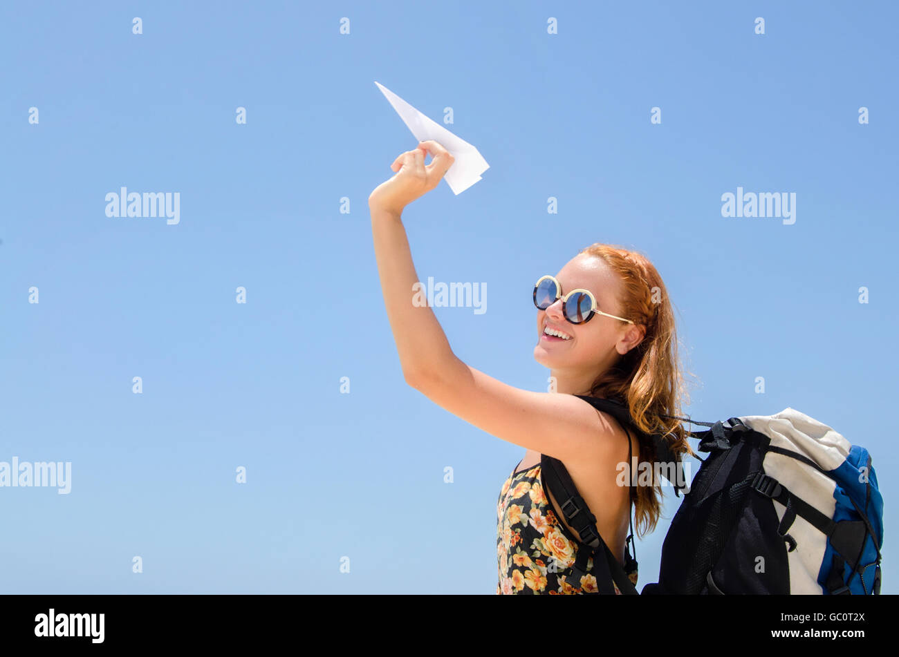 Ragazza backpacker invio di un aeroplano di carta Foto Stock