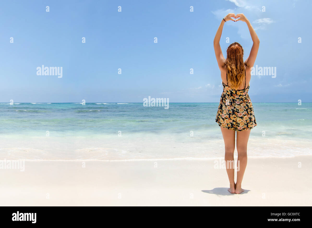 Giovani redhead donna fare un focolare con le mani Foto Stock