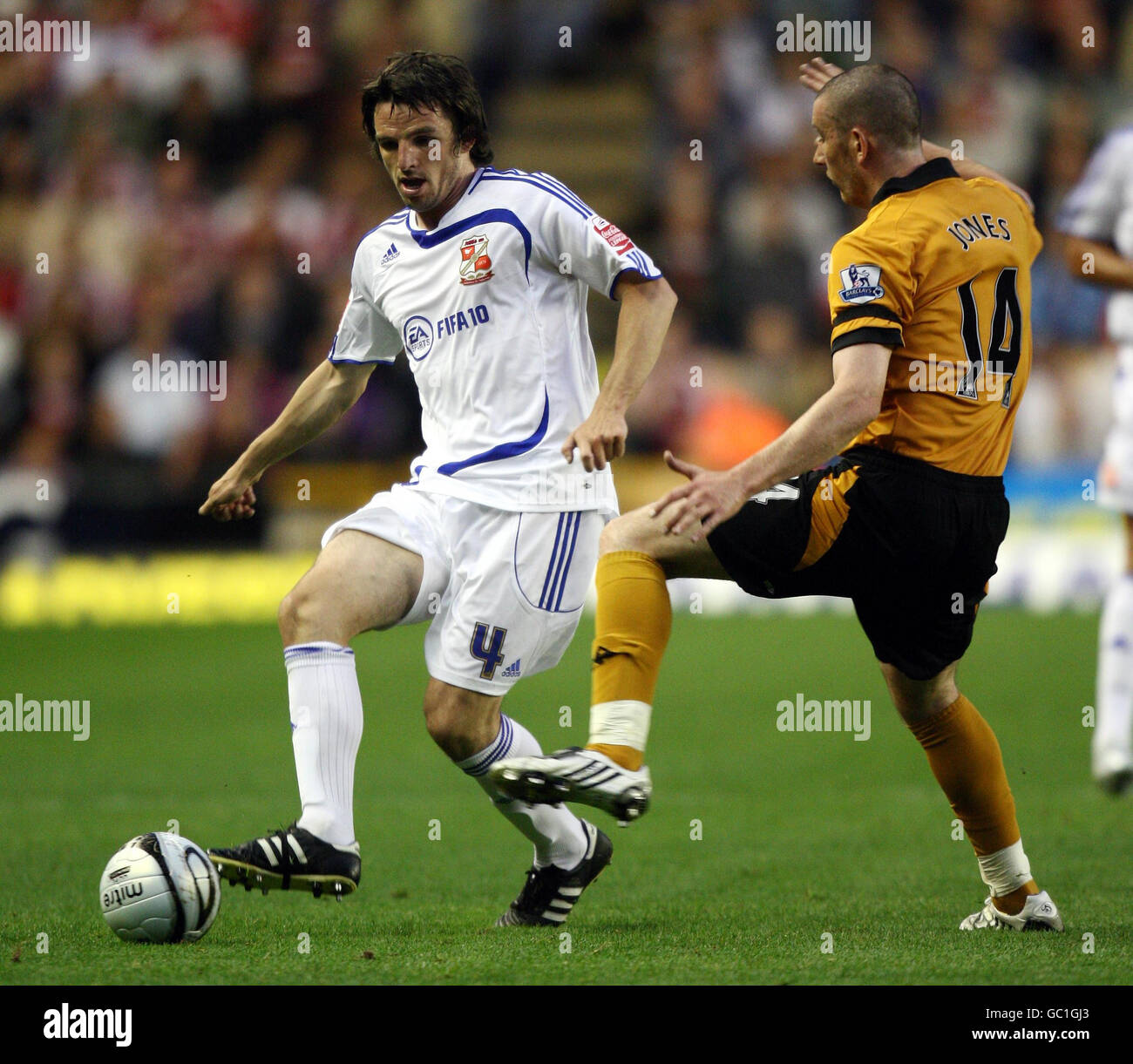 Jonathan Douglas di Swindon è combattuto da David Jones dei Lupi durante la seconda partita della Carling Cup a Molineux, Wolverhampton. Foto Stock