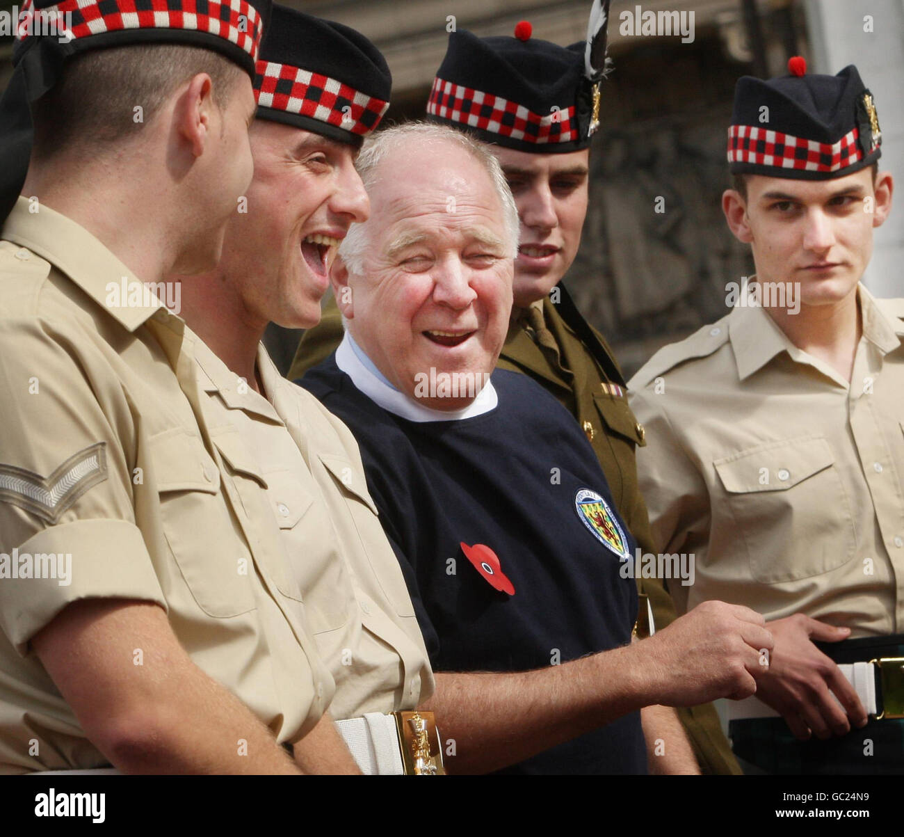 L'ex manager scozzese Craig Brown indossa una nuova camicia da calcio a marchio papavero mentre incontra i soldati del reggimento reale di Scozia al Cenotaph di George Square a Glasgow, per lanciare le due nuove maglie da calcio di beneficenza. Foto Stock