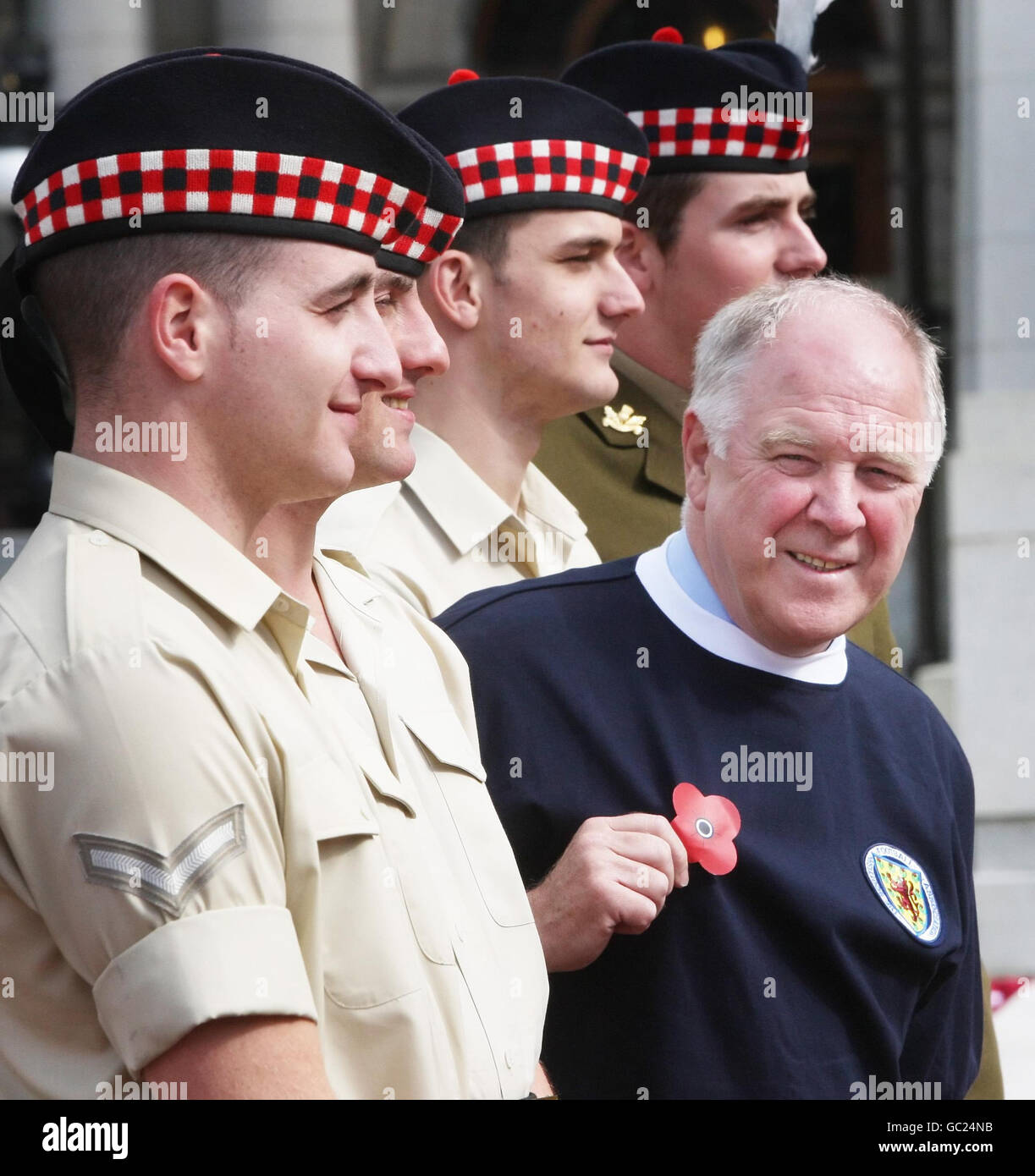 L'ex manager scozzese Craig Brown indossa una nuova camicia da calcio a marchio papavero mentre incontra i soldati del reggimento reale di Scozia al Cenotaph di George Square a Glasgow, per lanciare le due nuove maglie da calcio di beneficenza. Foto Stock