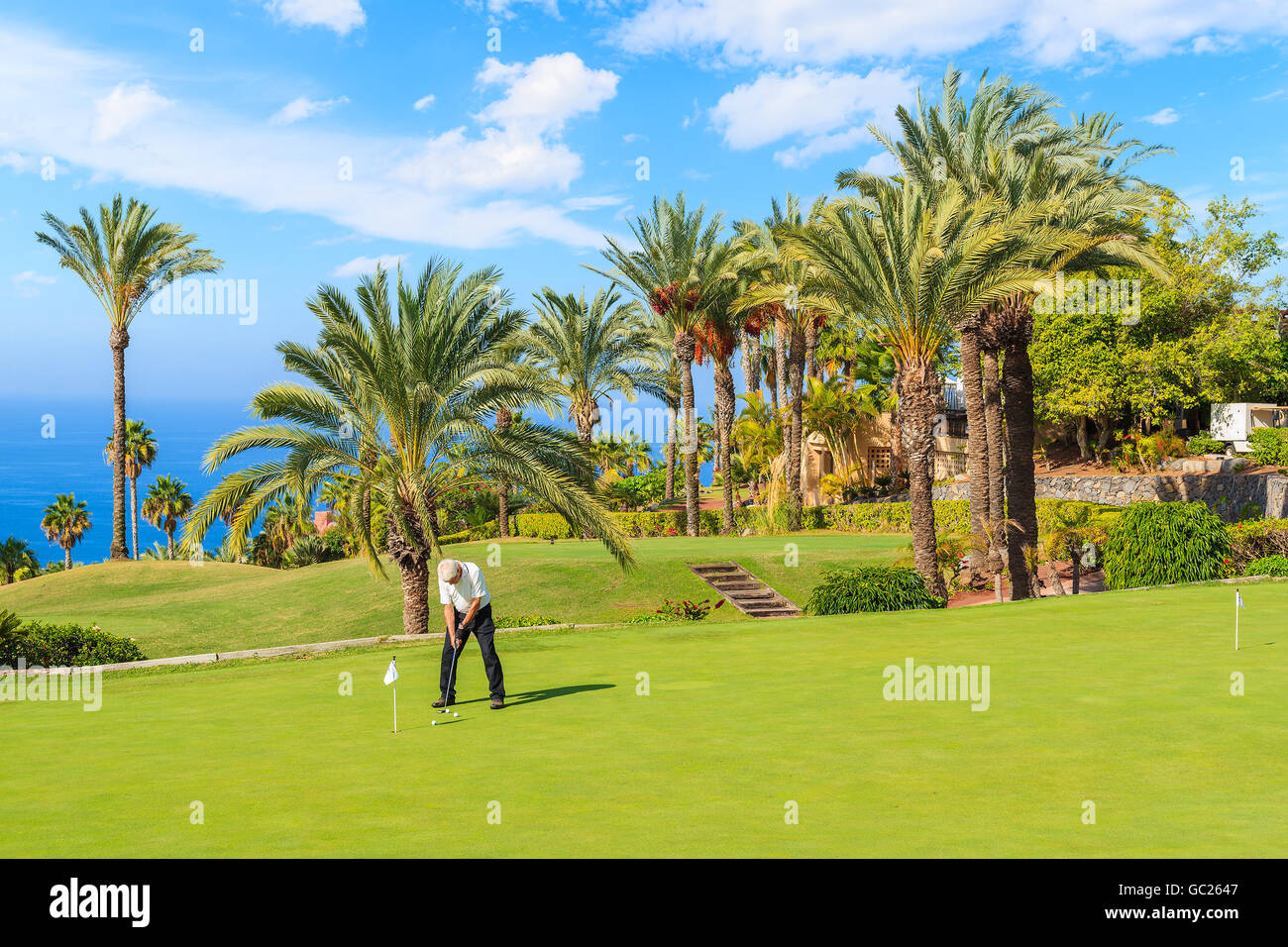 L uomo non identificato a giocare sul campo da golf nel paesaggio tropicale di Tenerife, Isole Canarie, Spagna Foto Stock