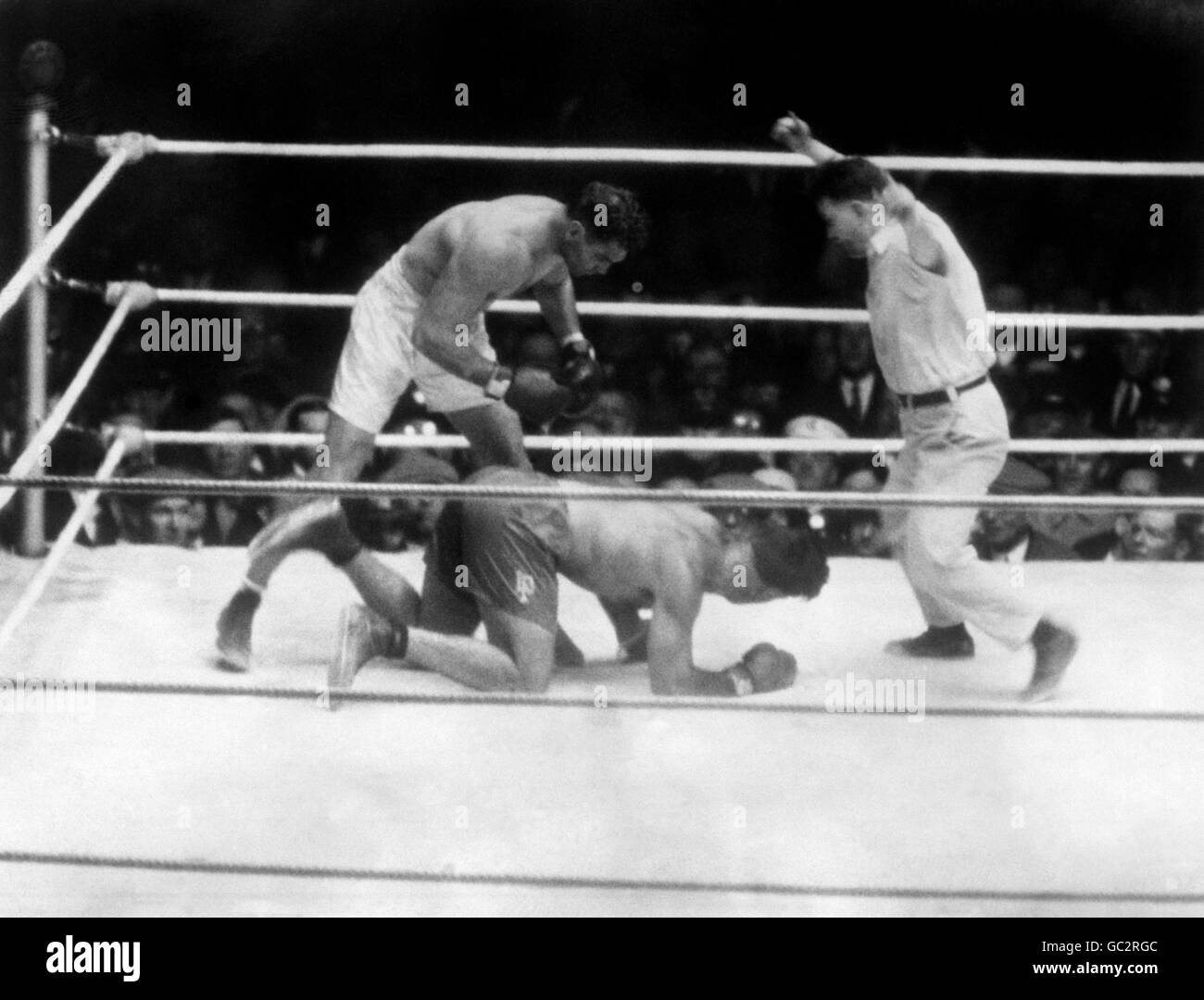 Pugilato - World Heavyweight Title - Jack Dempsey v Luis Firpo - Polo Grounds - New York. Luis Firpo cerca di alzarsi dopo essere stato inviato in tela da Jack Dempsey pochi secondi prima del finale knockout nel secondo turno. Foto Stock