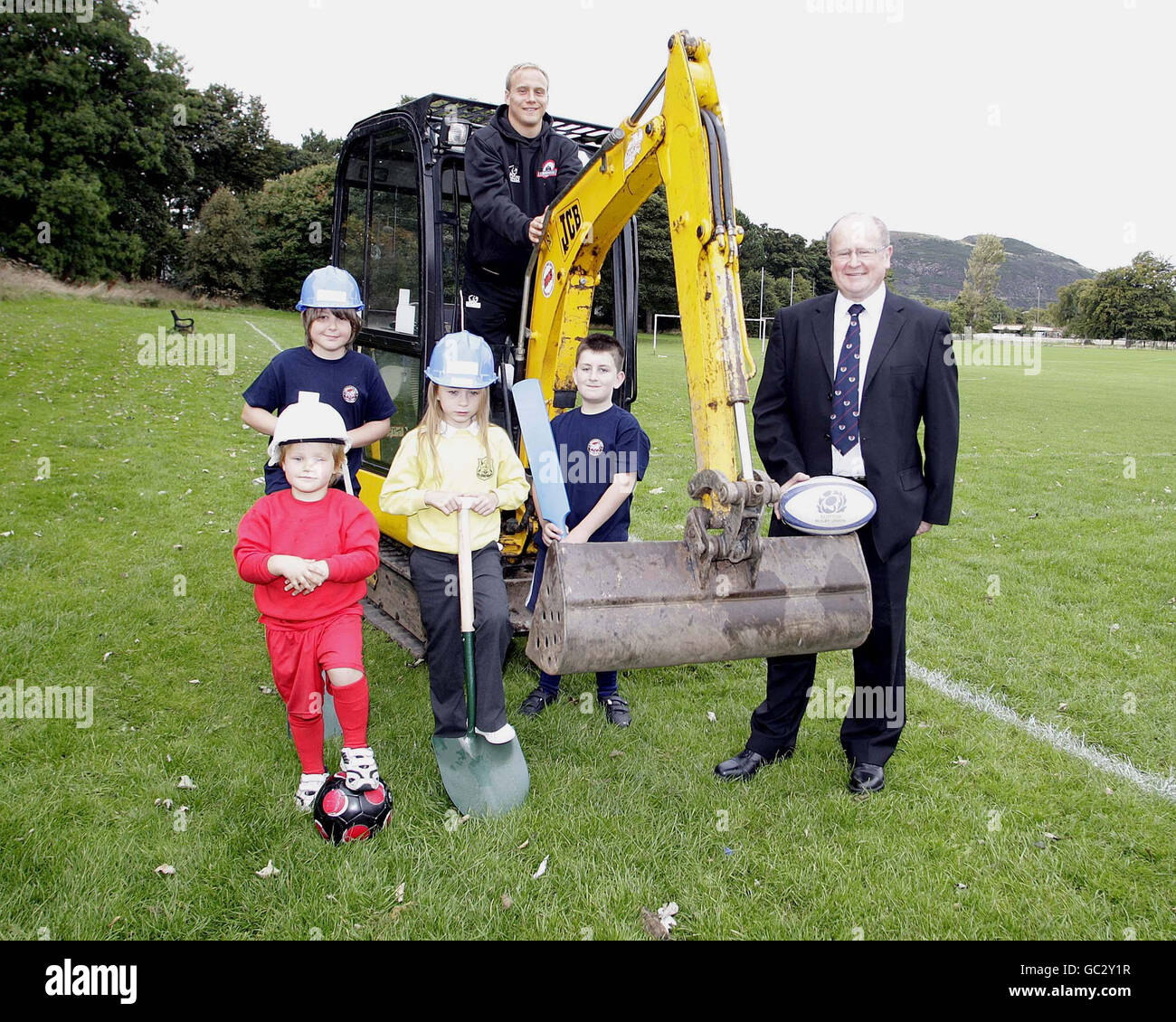 Il cantante di Edimburgo Andrew Turnbull (indietro) e Malcolm Gillies (all'estrema destra) del Lismobre RFC con bambini provenienti dal Lismore RFC, dal South FC di Edimburgo e dall'Edinburgh Cricket Club durante il lancio della costruzione di una struttura multisport per il Centro Sportivo di Inch Park Community a Inch Park, Edimburgo. Foto Stock