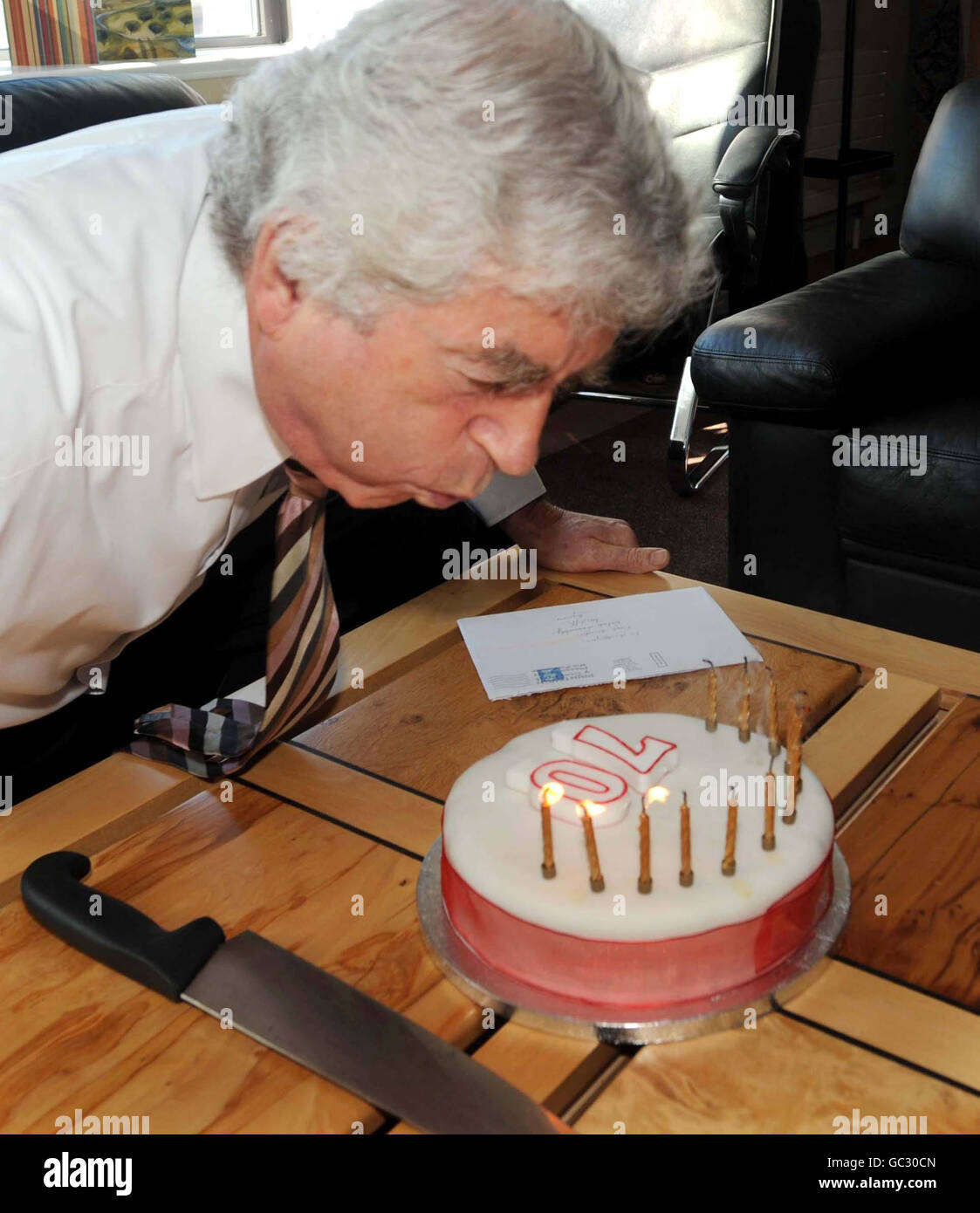 Il primo ministro gallese Rhodri Morgan soffia le candele sulla sua torta di settantesimo compleanno a Cardiff. Foto Stock