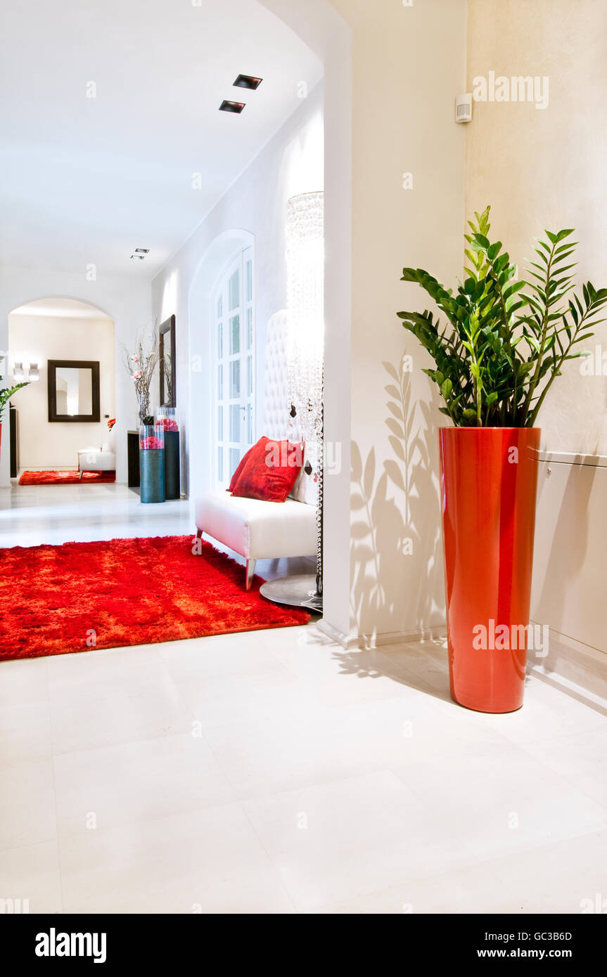 Casa moderna interni, corridoio con tappeto rosso e bianco poltrona Foto Stock