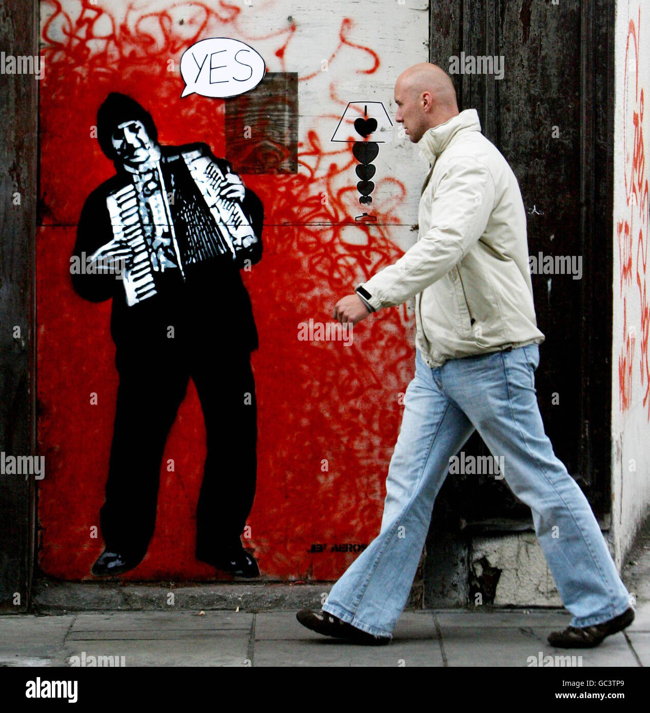 Un uomo cammina attraverso i graffiti del famoso artista francese Jef aerosol in Francis Street, Dublino, il giorno dopo che l'Irlanda ha votato Sì al trattato di Lisbona. Foto Stock