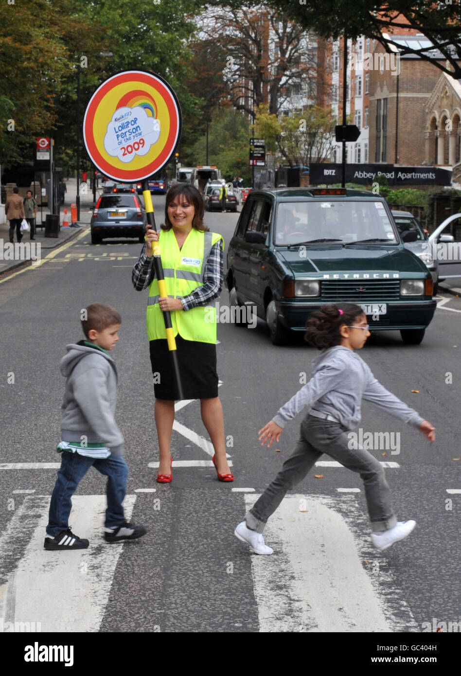 Il presentatore televisivo Lorraine Kelly ferma il traffico con gli studenti all'attraversamento pedonale di Abbey Road, a Londra, durante il lancio del Lollipop persona dell'anno Awards 2009. Foto Stock