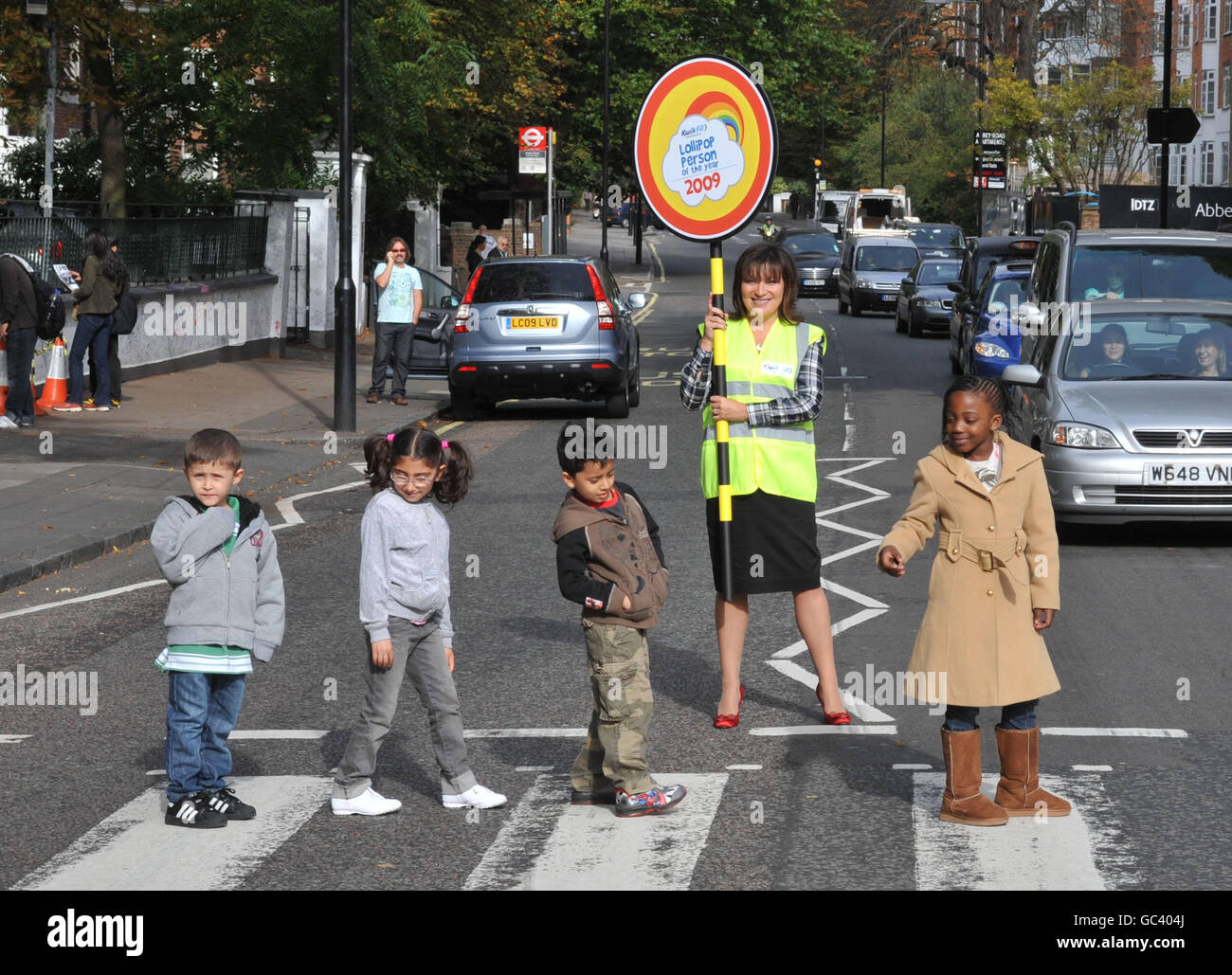 Il presentatore televisivo Lorraine Kelly ferma il traffico con gli studenti all'attraversamento pedonale di Abbey Road, a Londra, durante il lancio del Lollipop persona dell'anno Awards 2009. Foto Stock