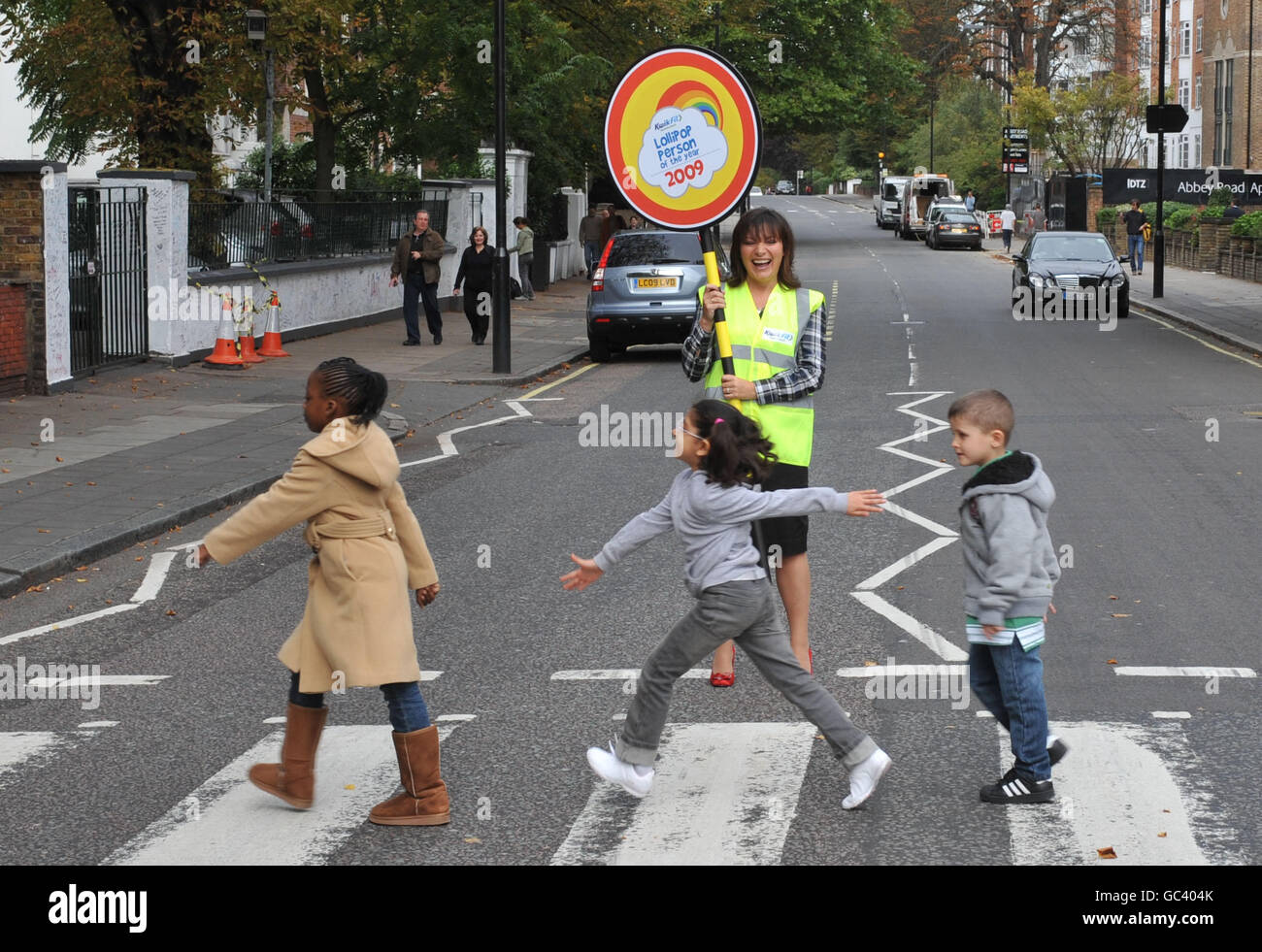 Il presentatore televisivo Lorraine Kelly ferma il traffico con gli studenti all'attraversamento pedonale di Abbey Road, a Londra, durante il lancio del Lollipop persona dell'anno Awards 2009. Foto Stock