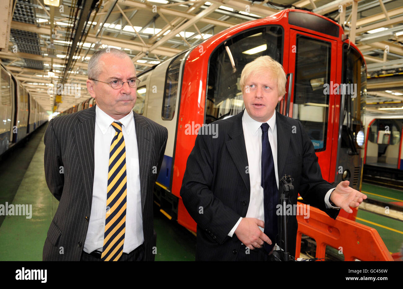 Il sindaco di Londra Boris Johnson (a destra) e il boss TfL Peter Hendy al deposito del treno della metropolitana di Northumberland Park, mentre fanno annunci relativi ai nuovi treni T2 (mostrati in background) e modifiche al sistema della zona di congestione. Foto Stock