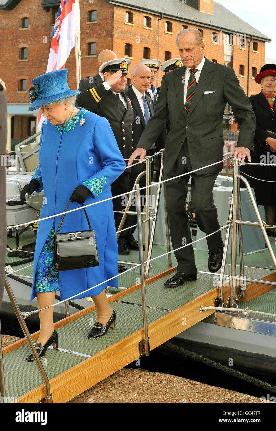 La regina Elisabetta II e il duca di Edimburgo camminano lungo una gangplank mentre arrivano al Gloucestershire College, sulle rive del fiume Severn durante una visita al nuovo edificio. Foto Stock