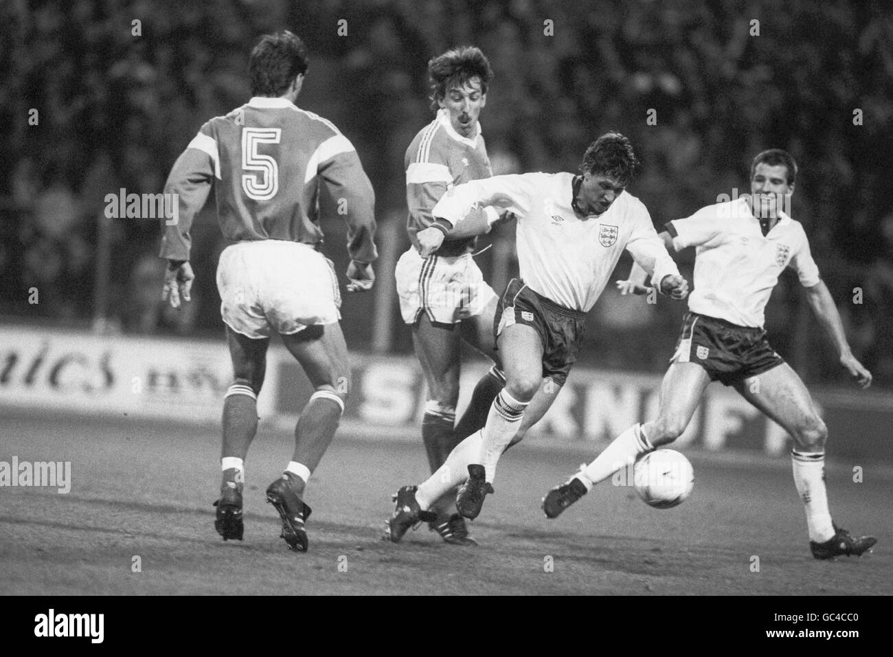 Gary Lineker in Inghilterra passa Faruk Hadzibegic (n.5) e Zoran Vulic in Inghilterra come Steve Bull orologi, a destra. Foto Stock