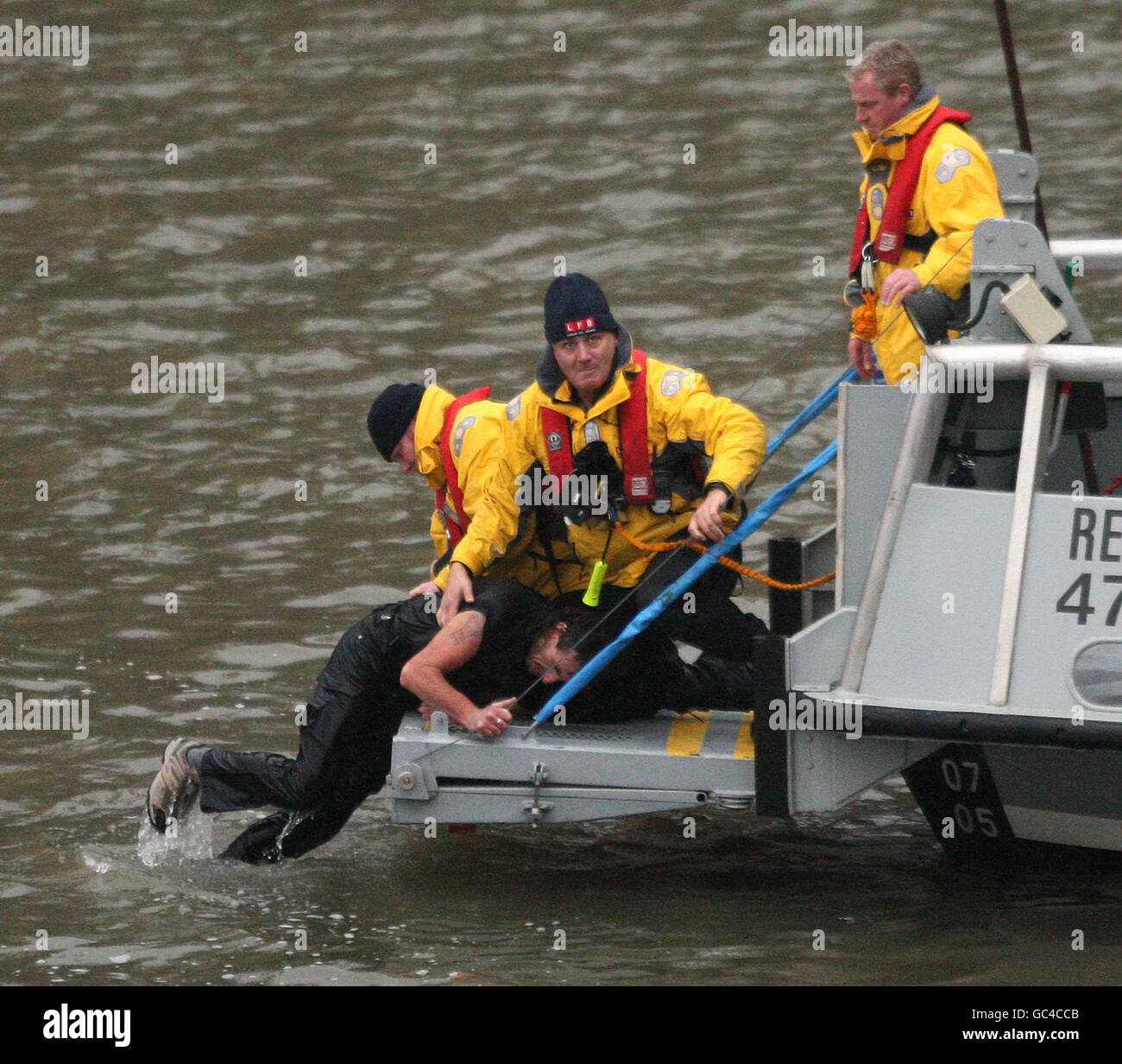 Un uomo tirato dal fiume Tamigi dall'equipaggio di una London Fire Brigade lancio dopo il salto da Westminster Bridge, Londra. Foto Stock