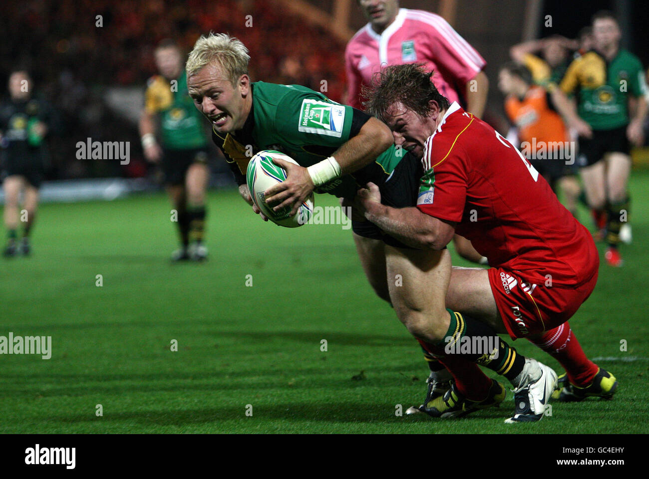 La Shane Geraghty di Northampton ha fatto una prova nonostante le attenzioni della Jerry Flannery di Munster durante la partita della Heineken Cup ai Franklin's Gardens di Northampton. Foto Stock