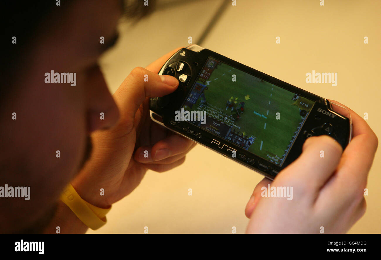 Giochi per computer. Un uomo gioca un gioco su una console Sony PSP. Foto Stock