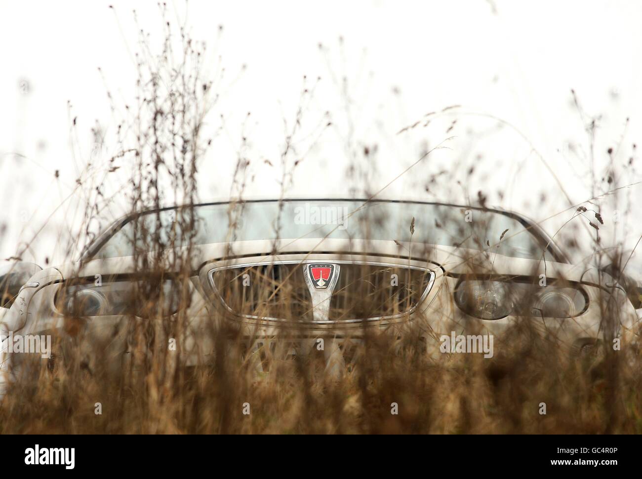 Una Rover 75 può essere vista attraverso le erbacce, mentre i vecchi edifici sono in disuso o demoliti mentre i nuovi sviluppi progrediscono presso LO stabilimento DI AUTOMOBILI MG Rover a Longbridge, Birmingham Foto Stock