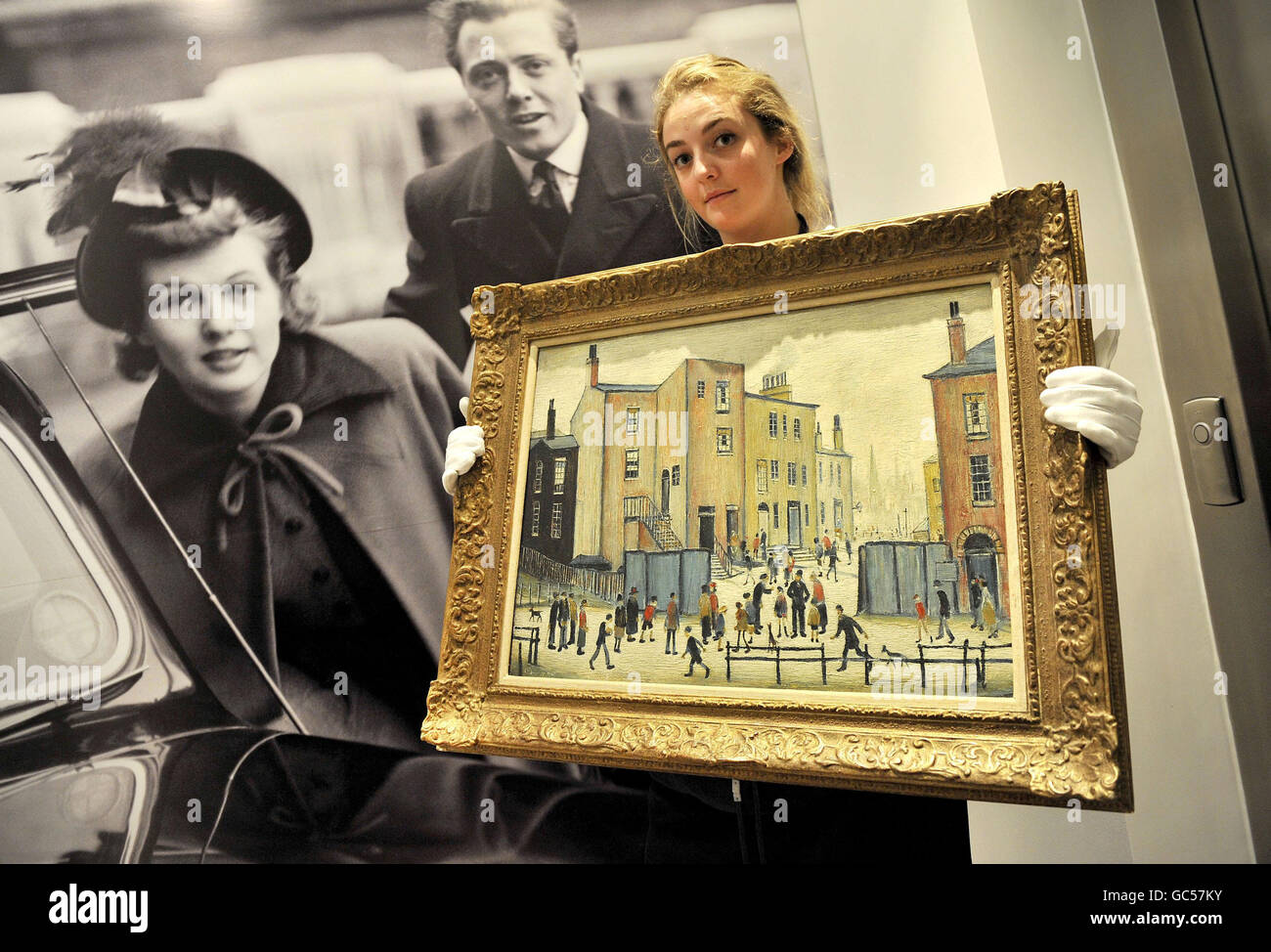 Il tecnico di Sotheby, Chloe Stead, detiene le "Old Houses" di L. S. Lowry, parte della collezione di dipinti di proprietà di Lord e Lady Attendborough a Sotheby's a Londra, che saranno messi all'asta il 11 novembre. Foto Stock
