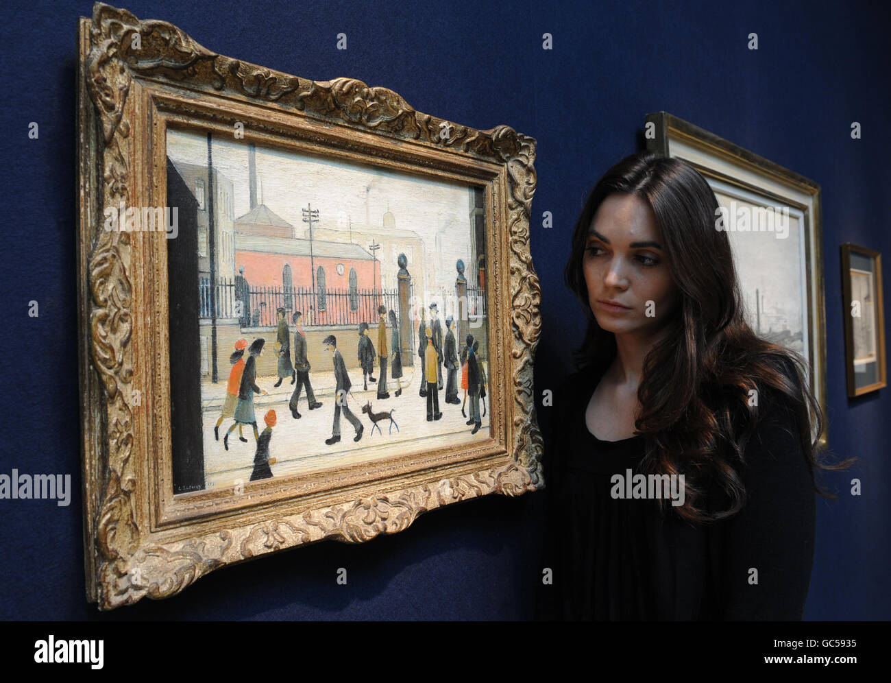 Un dipendente di Christies guarda un dipinto di LS Lowry intitolato The Gateway che è stato acquistato dal compianto attore Peter Barkworth per 57 nel 1955 e sarà in vendita giovedì 12 novembre per un valore stimato di 150,000 - 250,000. Foto Stock