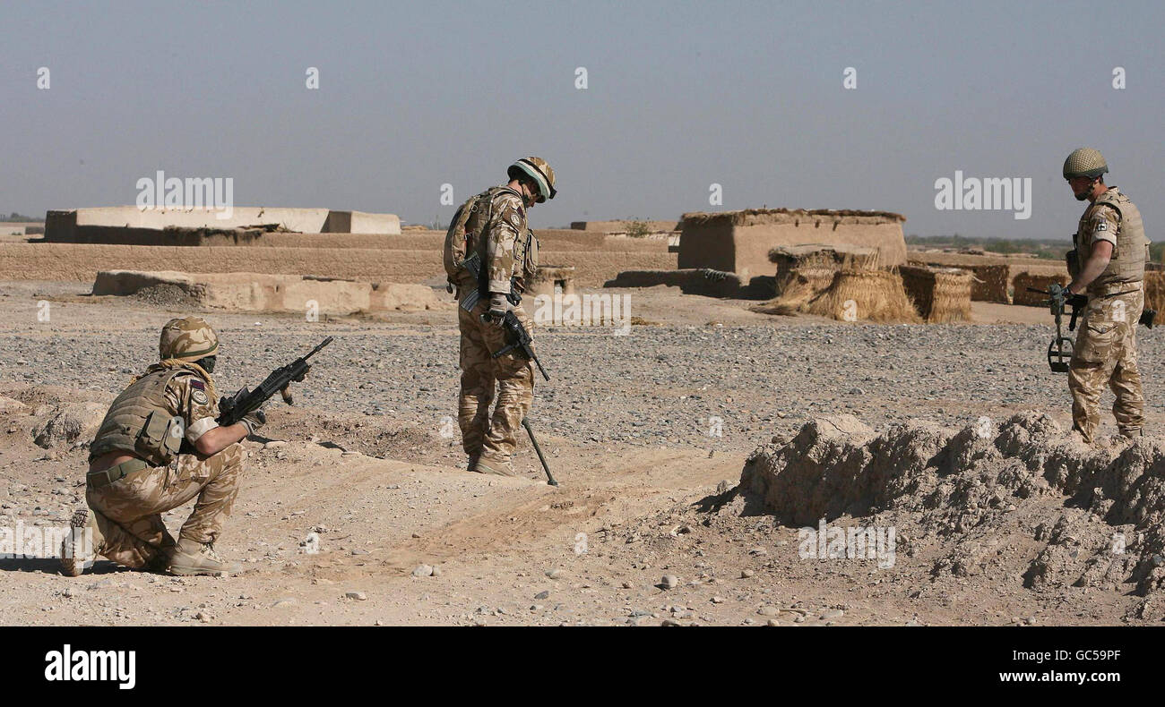 Soldati del 1 ° Battaglione, Grenadier guardie 'Barma', (termine militare per cercare) il terreno, utilizzando un metal detector per controllare i dispositivi I.E.D, su una rotta in Basharan, Afghanistan. Foto Stock
