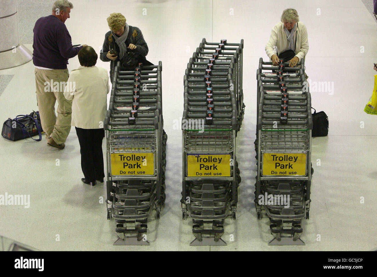 I passeggeri ritirano un trolley prima di attendere i bagagli all'aeroporto di Manchester, terminal 2. Foto Stock