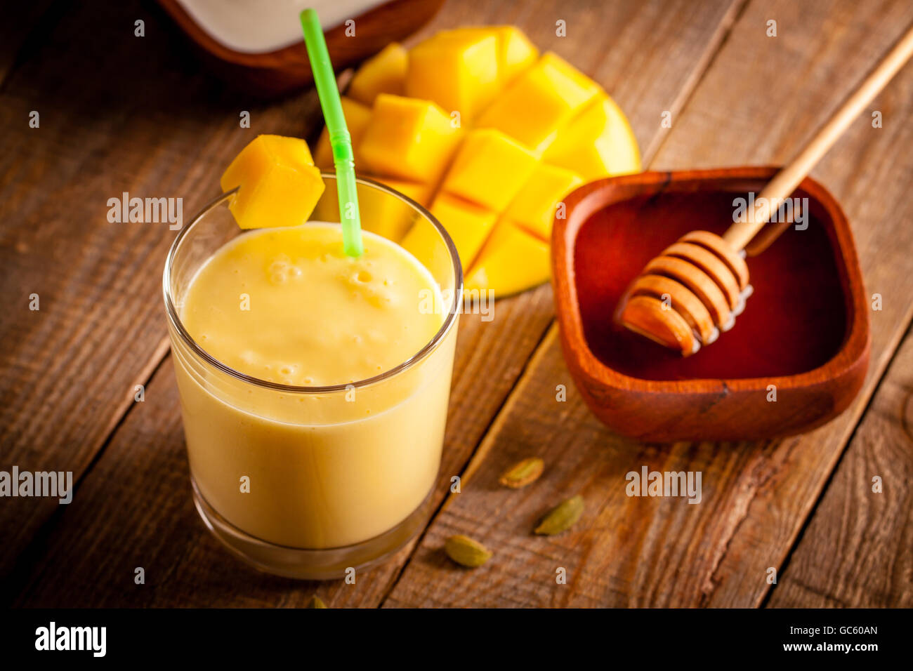 Bicchiere di mango lassi, Indiano bevanda a base di yogurt mescolato con mango e miele, aromatizzata con il cardamomo. Foto Stock