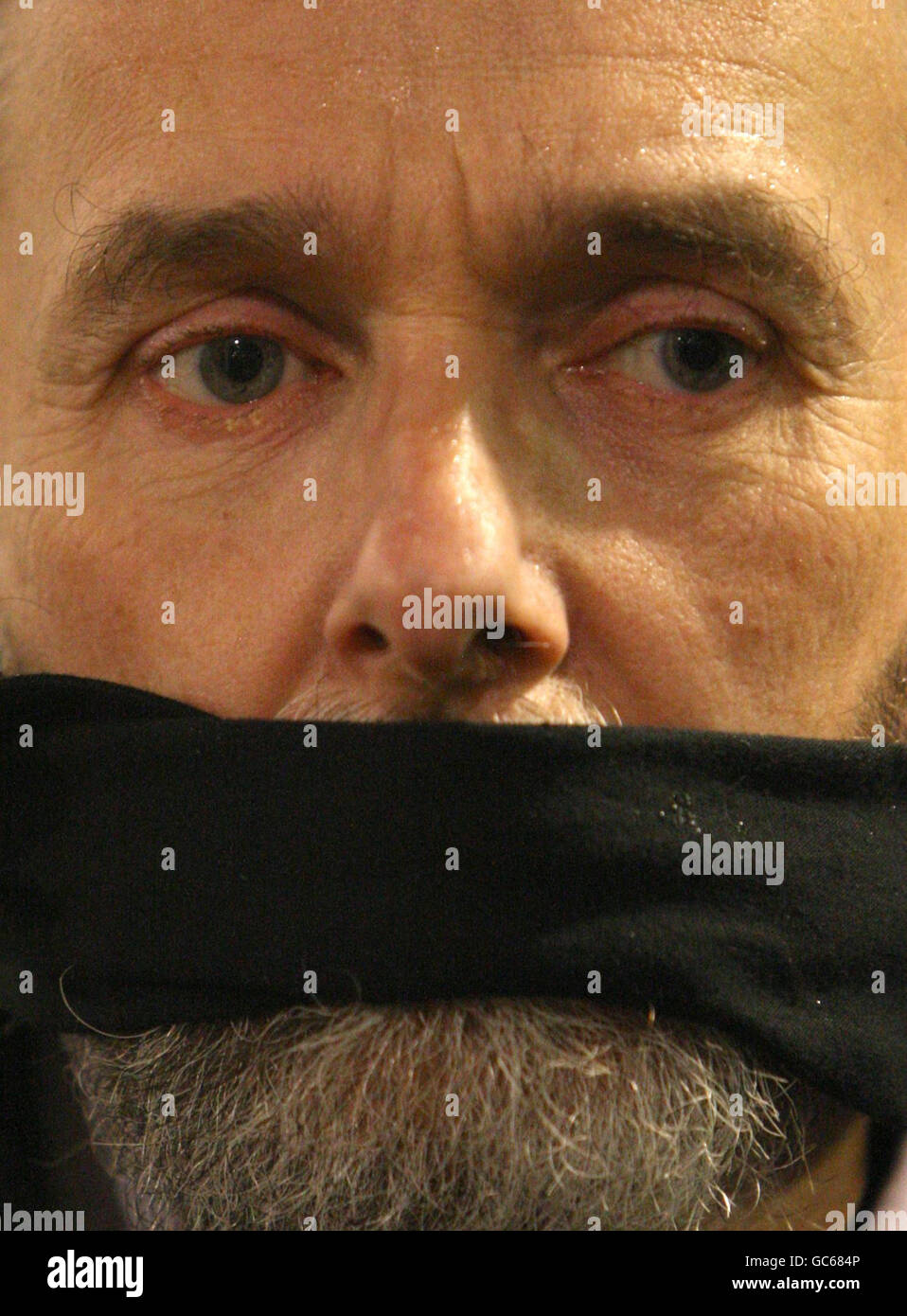 Un dimostratore indossa un bavaglio, mentre i manifestanti chiedono il rilascio del caporale di Lance Joe Glenton, che si trova di fronte a accuse di diserzione per non essere rientrato in Afghanistan, al di fuori del Ministero della Difesa, Westminster, Londra. Foto Stock