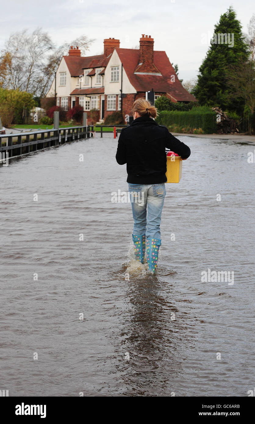 Amy Gaskell porta la sua casa per lo shopping attraverso le crescenti acque alluvionali del fiume Ouse a Naburn, York, come gli esperti avvertono che il deflusso è previsto per continuare nel nord dell'Inghilterra, nel Galles nord-occidentale e nella Scozia occidentale. Foto Stock