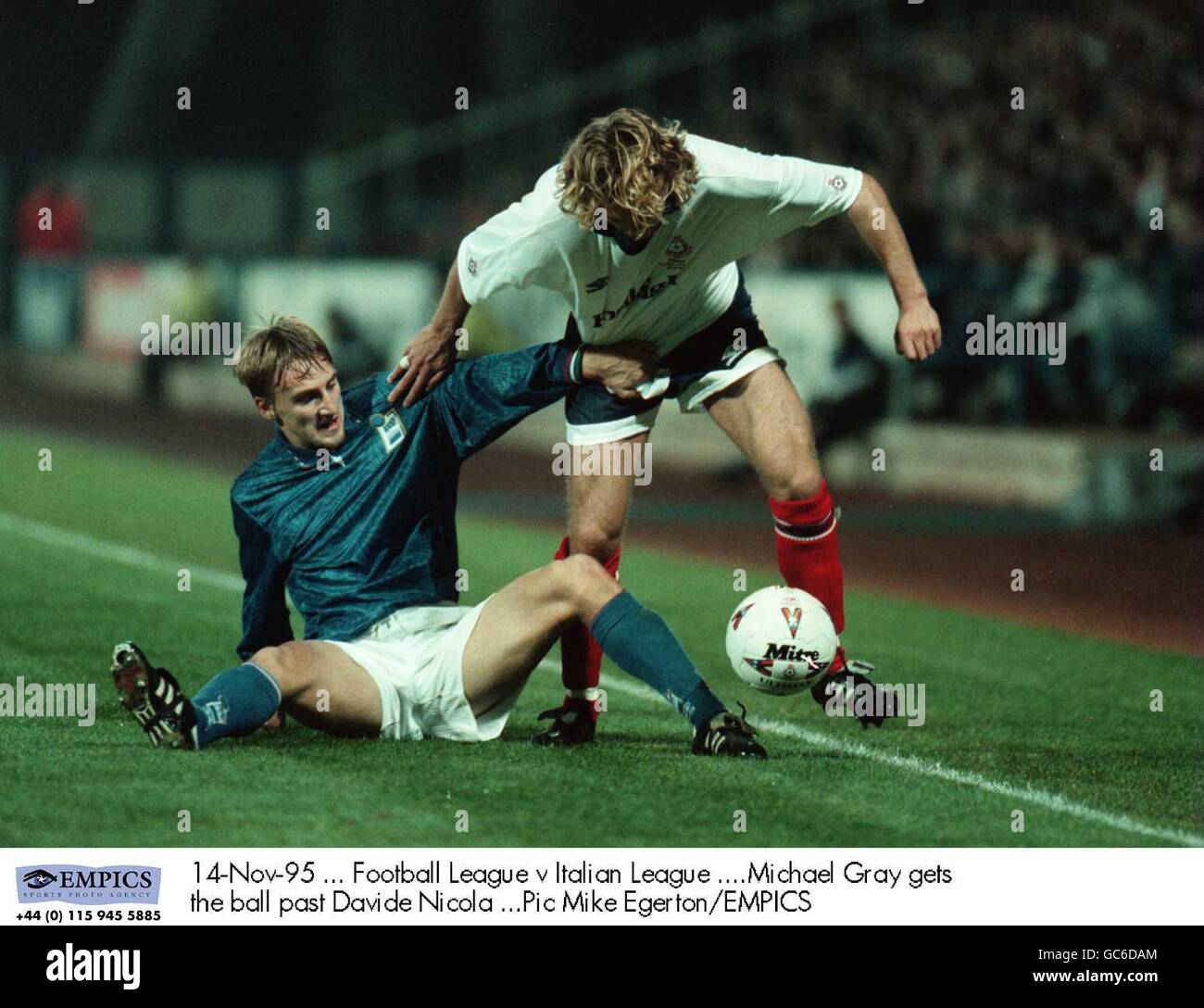 14-Nov-95, Football League contro Italian League, Michael Gray ottiene la palla oltre Davide Nicola Foto Stock