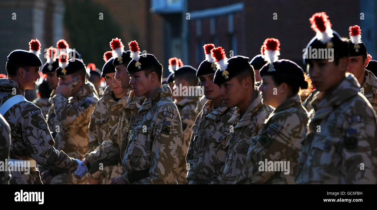 Un sole invernale basso mette in evidenza gli hackle sulle berrette dei soldati del secondo Battaglione il reggimento reale dei Fusiliers mentre si preparano a marciare attraverso Warwick mentre segnano il loro ritorno a casa dalle operazioni in Iraq e Afghanistan. Foto Stock