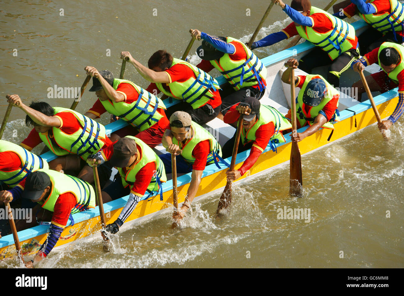 Lavoro di squadra di uomo, canottaggio dragon boat in racing, provare a fila ad alta velocità e con lo spirito del campionato, il ritmo della paletta in modo dinamico Foto Stock