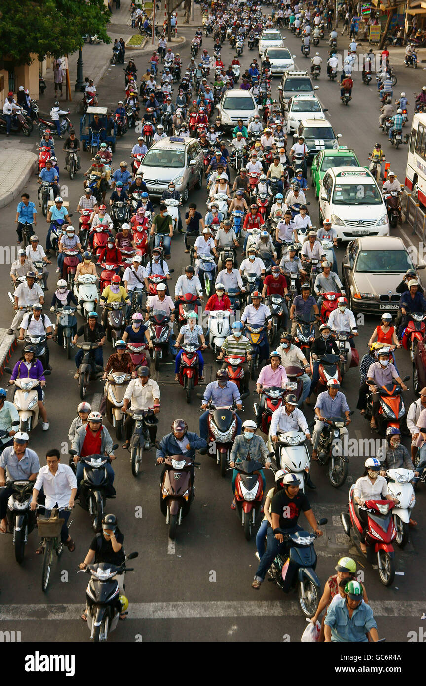 Atmosfera affollata in ora di punta, gruppo di moto, grande singolo veicolo rendono pressuse sul traffico urbano, aria inquinamento Foto Stock