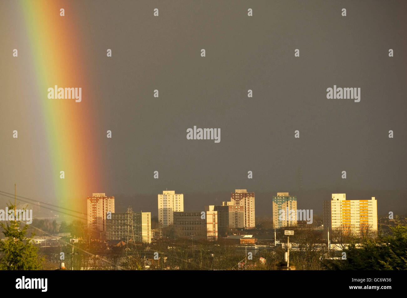 Un arcobaleno si forma sopra i blocchi della torre nella zona di Barton Hill di Bristol, durante una pesante discesa sopra la città intorno all'alba. Foto Stock