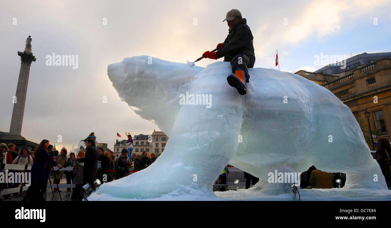 Lo scultore Mark Coreth si trova in cima alla sua scultura a grandezza naturale "Ice Bear" in Trafalgar Square di Londra, come parte della campagna del WWF per evidenziare la situazione degli orsi nell'Artico, dove i sicecap in fusione minacciano la loro sopravvivenza. Foto Stock