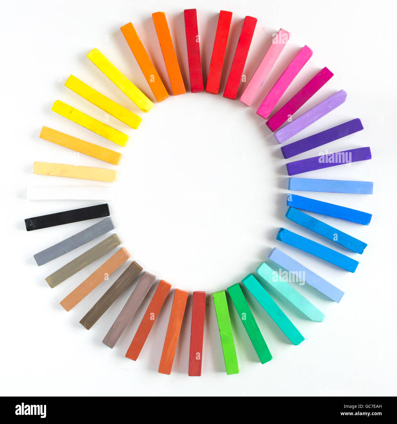 Gessi colorati schierate arrotondato sul cerchio su sfondo bianco Foto Stock
