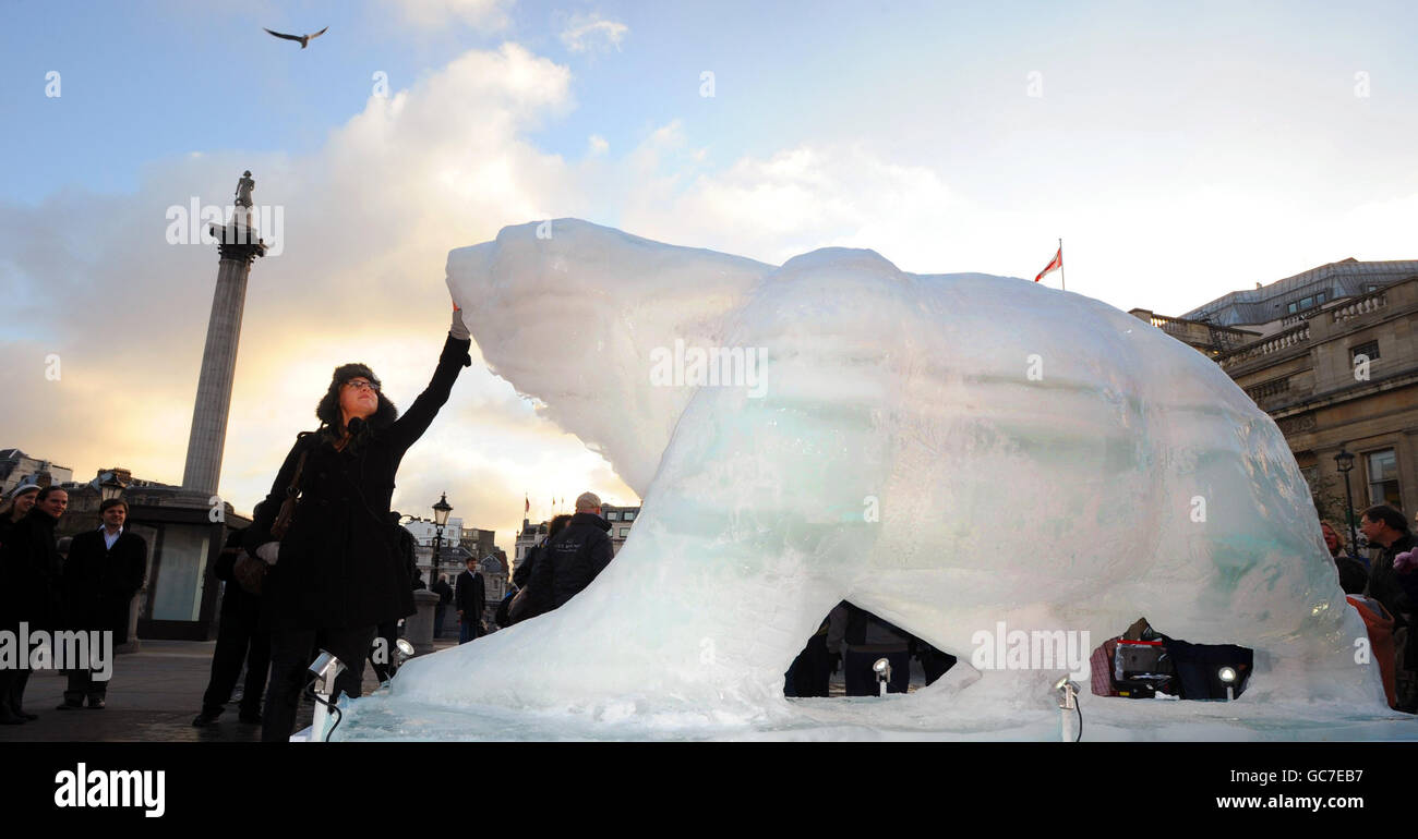 Un membro del pubblico tocca una scultura a grandezza naturale "Ice Bear" nella Trafalgar Square di Londra, come parte della campagna del WWF per evidenziare la situazione degli orsi nell'Artico, dove i sicecap in fusione minacciano la loro sopravvivenza. Foto Stock