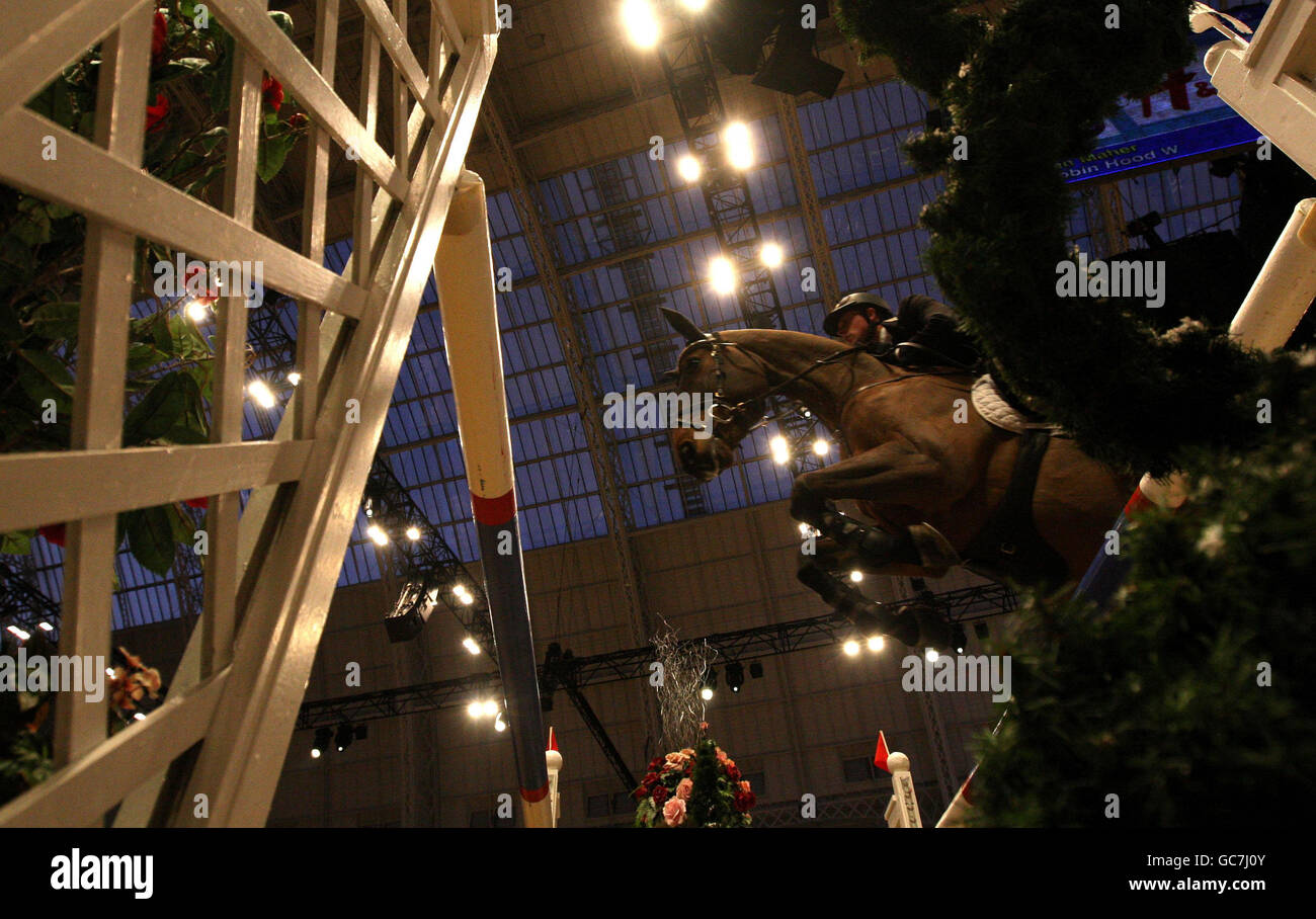 Un cavallo e un cavaliere si fanno strada sui salti del Rolex FEI Worldcup Jumping durante il London International Horse Show presso l'Olympia Exhibition Centre di Londra. Foto Stock