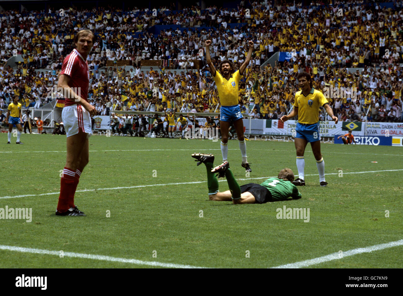 Calcio - Coppa del mondo FIFA Messico 86 - Round of 16 - Brasile / Polonia - Estadio Jalisco, Guadalajara. Il Brasile Socrates (armi sollevate) celebra l'obiettivo di Josimar contro la Polonia con Careca, a destra, mentre il romano polacco Wojcicki guarda a sinistra. Foto Stock