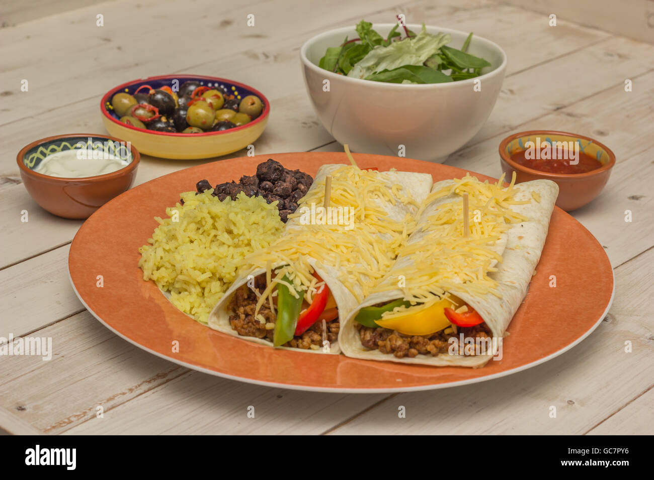 Burrito riempiti con carne macinata di manzo e peperoni con riso e fagioli sul lato Foto Stock