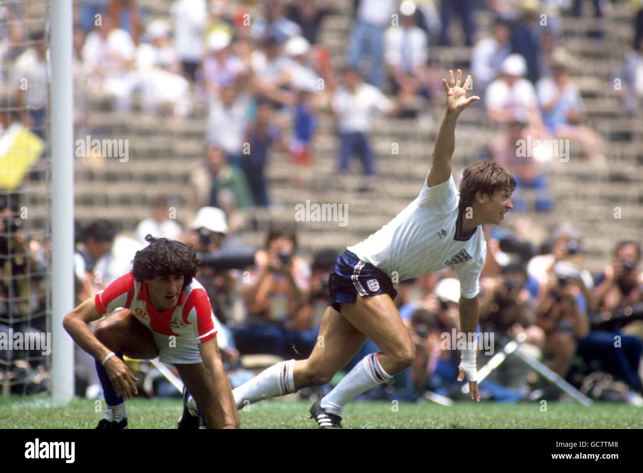 Calcio - Coppa del mondo Messico 1986 - secondo turno - Inghilterra / Paraguay - Estadio Azteca, Città del Messico. Gary Lineker dell'Inghilterra festeggia il raggiungimento di uno dei suoi due gol mentre Cesar Zabala del Paraguay sembra abbattuto Foto Stock