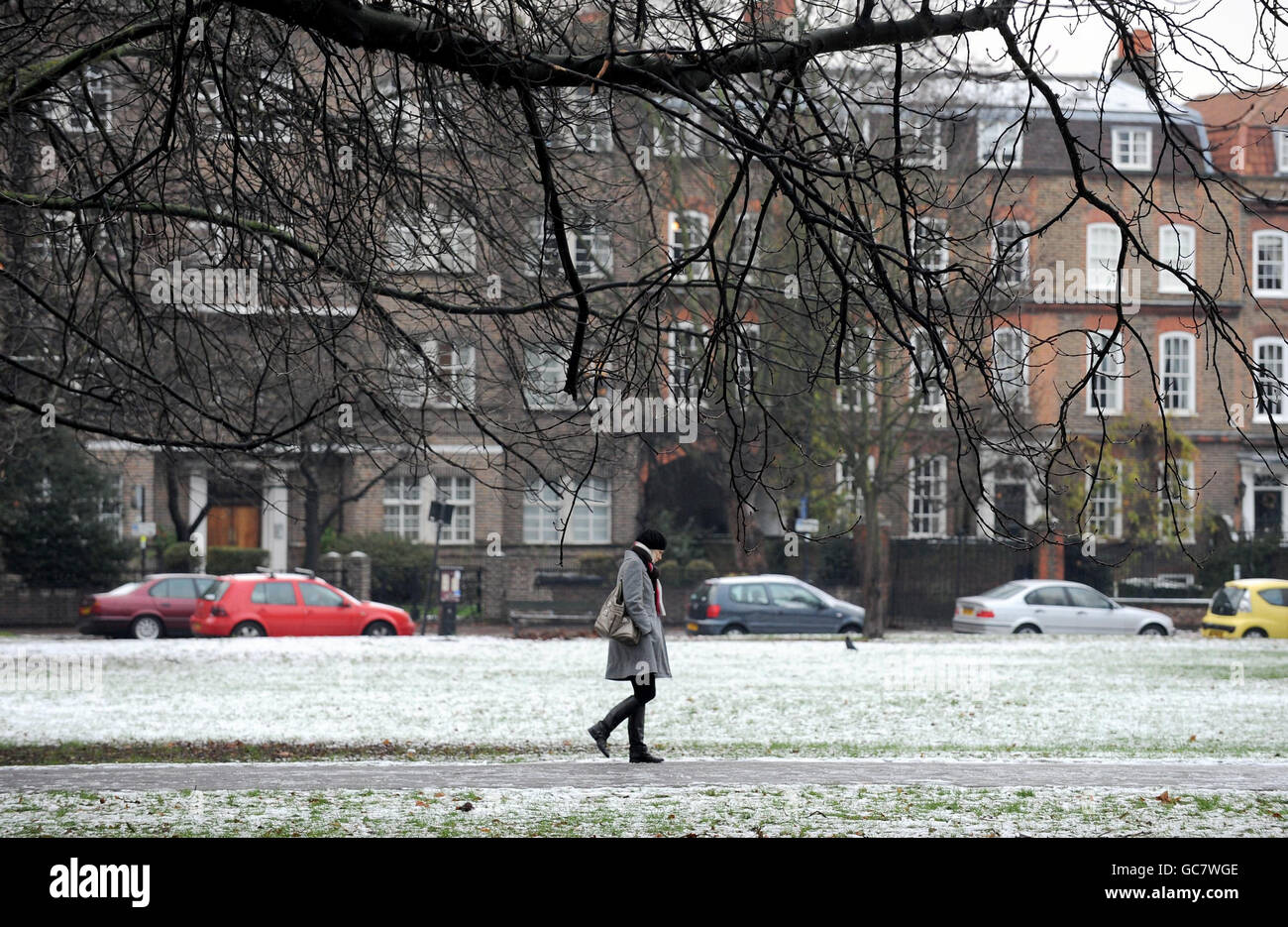 Una donna cammina lungo un sentiero ghiacciato mentre la neve copre ancora il terreno a Clapham Common, Londra. Foto Stock