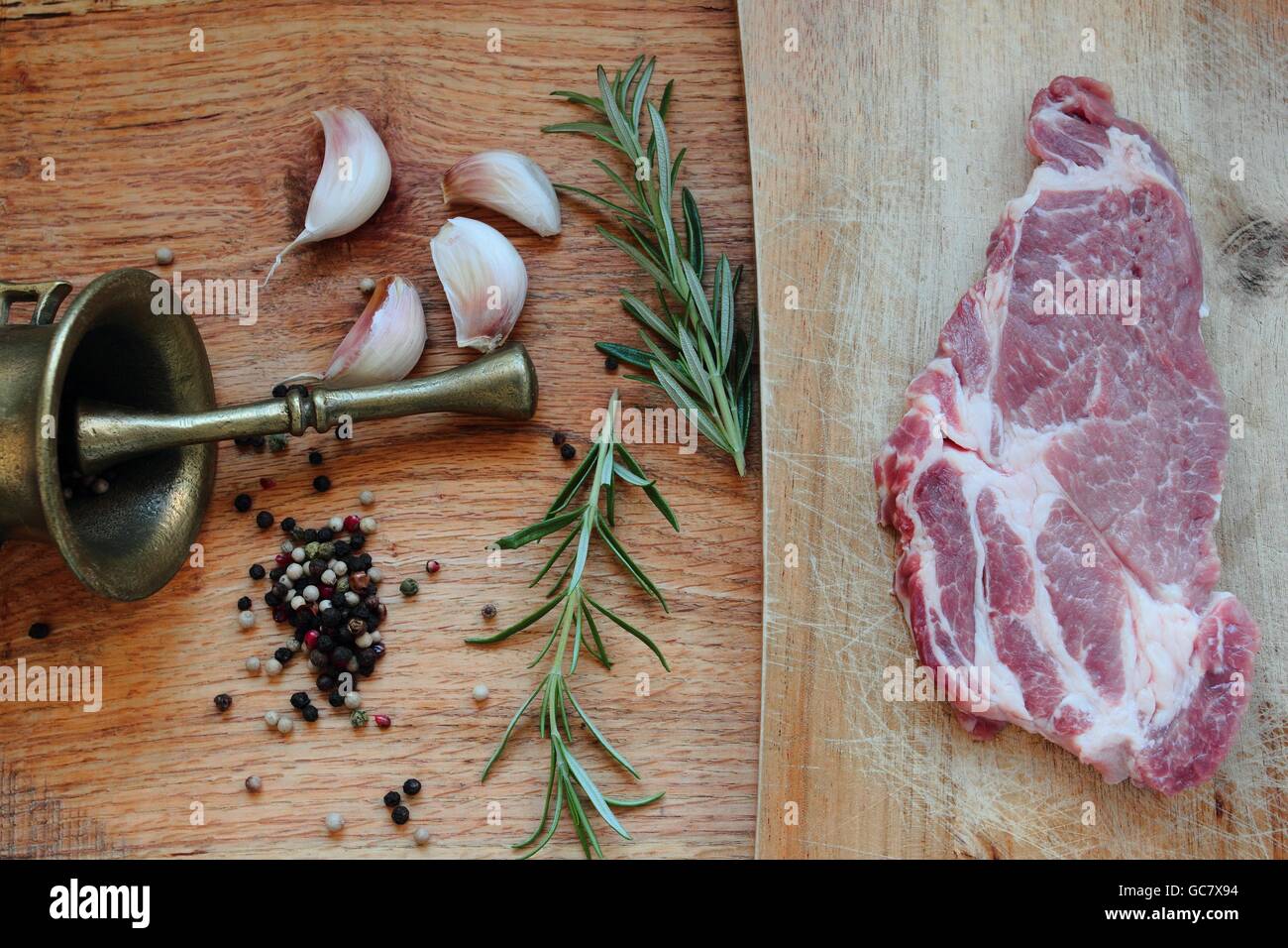 La carne di maiale. Carne cruda con erbe su una tavola di legno Foto Stock