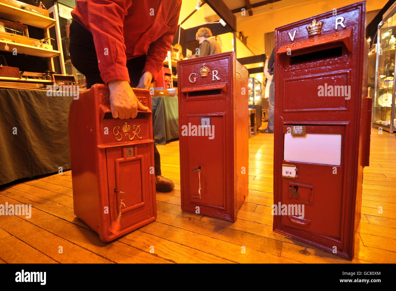 Tre caselle postali rosse Royal Mail, tra cui una vittoriana (a destra) presso la Westonbirt Antiques & fine Art Fair alla scuola Westonbirt vicino a Tetbury, Gloucestershire, dove sono stati venduti con altri esempi di oggetti medici e scientifici antichi. Foto Stock