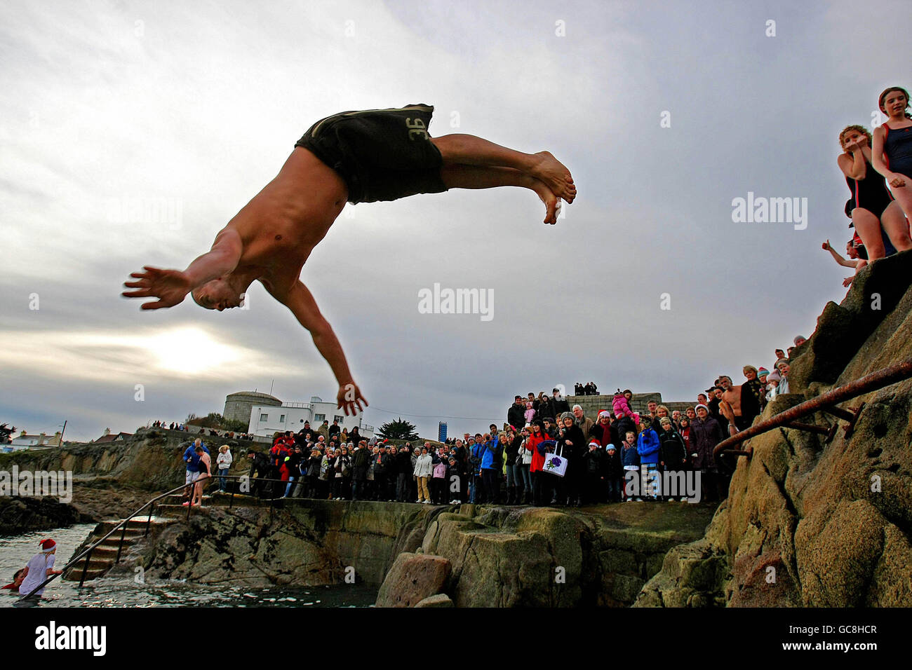 I membri del pubblico si sfidano al freddo e alle condizioni del ghiaccio per un tuffo nel mare d'Irlanda nel punto di balneazione di 40 metri a Sandycove, Dublino, durante la nuotata annuale del giorno di Natale. Foto Stock