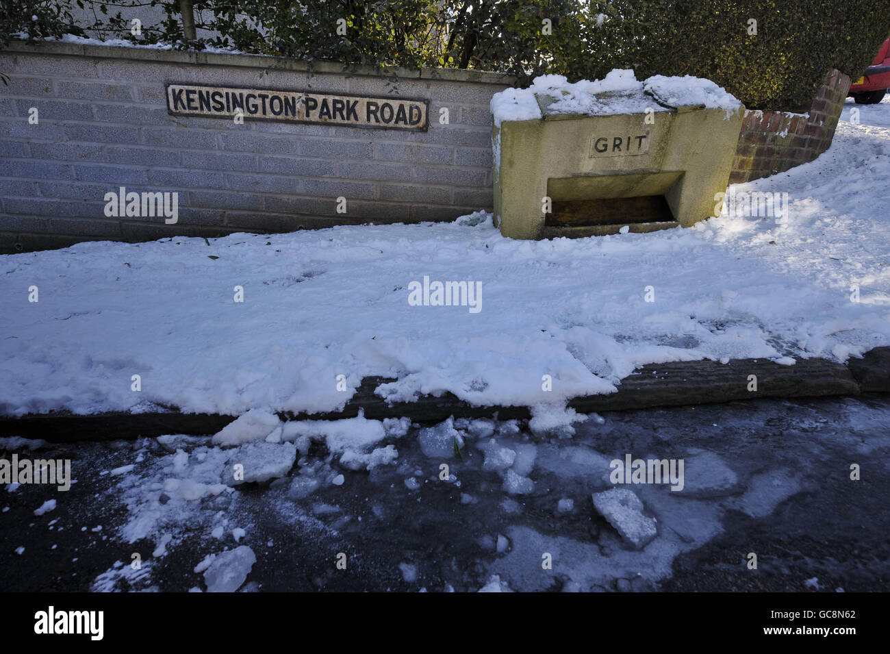 Una scatola vuota di sabbia su Kensington Park Road, Brislington, Bristol, con ghiaccio in lamiera sulla strada non trattata dopo un'acqua di scoppio principale inondata la strada e ha causato il ghiaccio di formare. Foto Stock