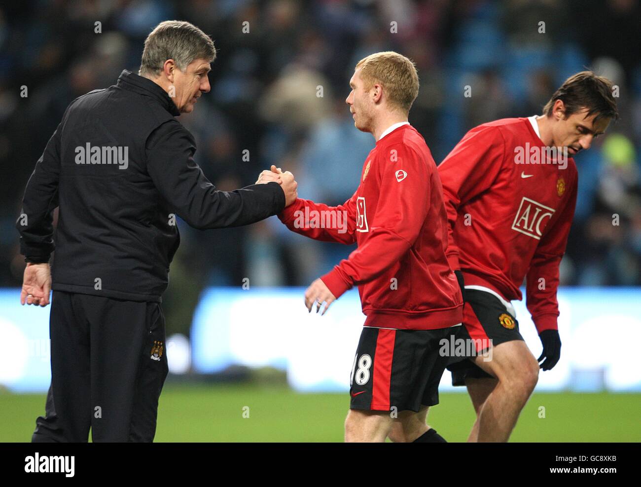 L'assistente manager di Manchester City Brian Kidd (a sinistra) scuote le mani con Paul Scholes (al centro) del Manchester United mentre il compagno di squadra Gary Neville (a destra) si trova nelle vicinanze Foto Stock